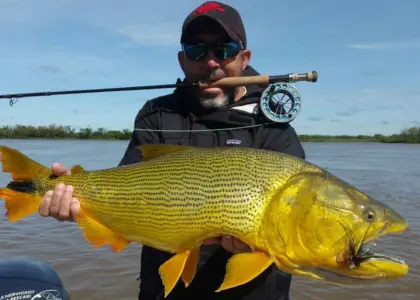 Pescador mostrando un dorado en la zona de Yacyretá, río Paraná, Paraguay
