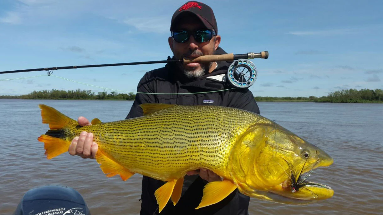 Pescador mostrando un dorado en la zona de Yacyretá, río Paraná, Paraguay